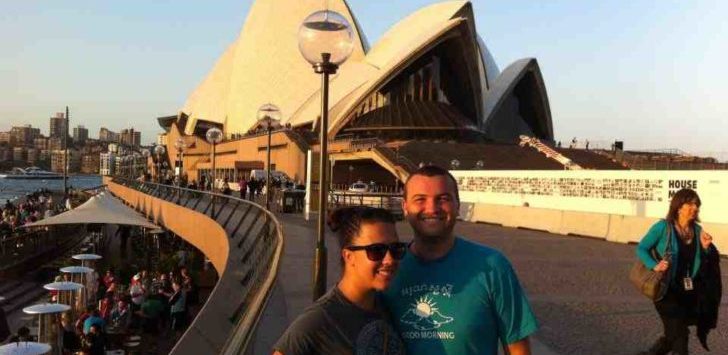 a man and woman posing for a picture in front of a building