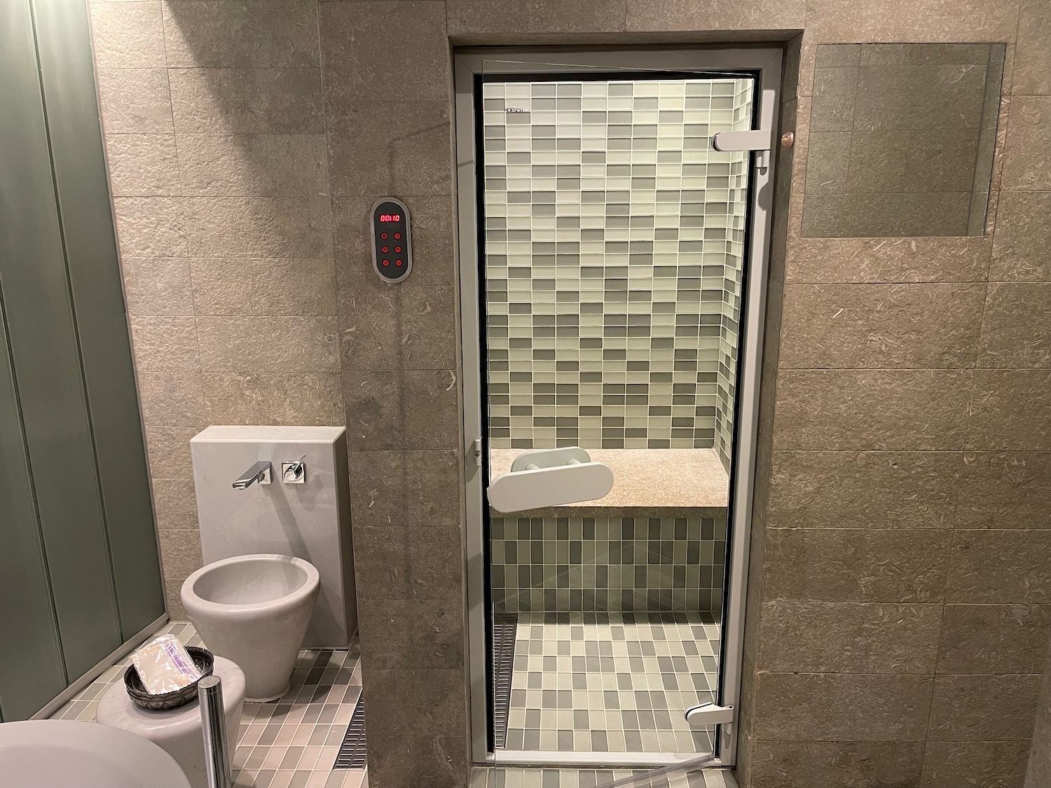 a bathroom with a glass door and a toilet