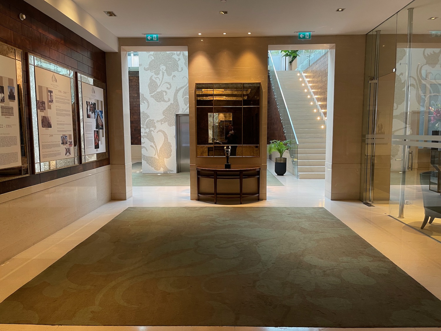 a hallway with stairs and a glass wall