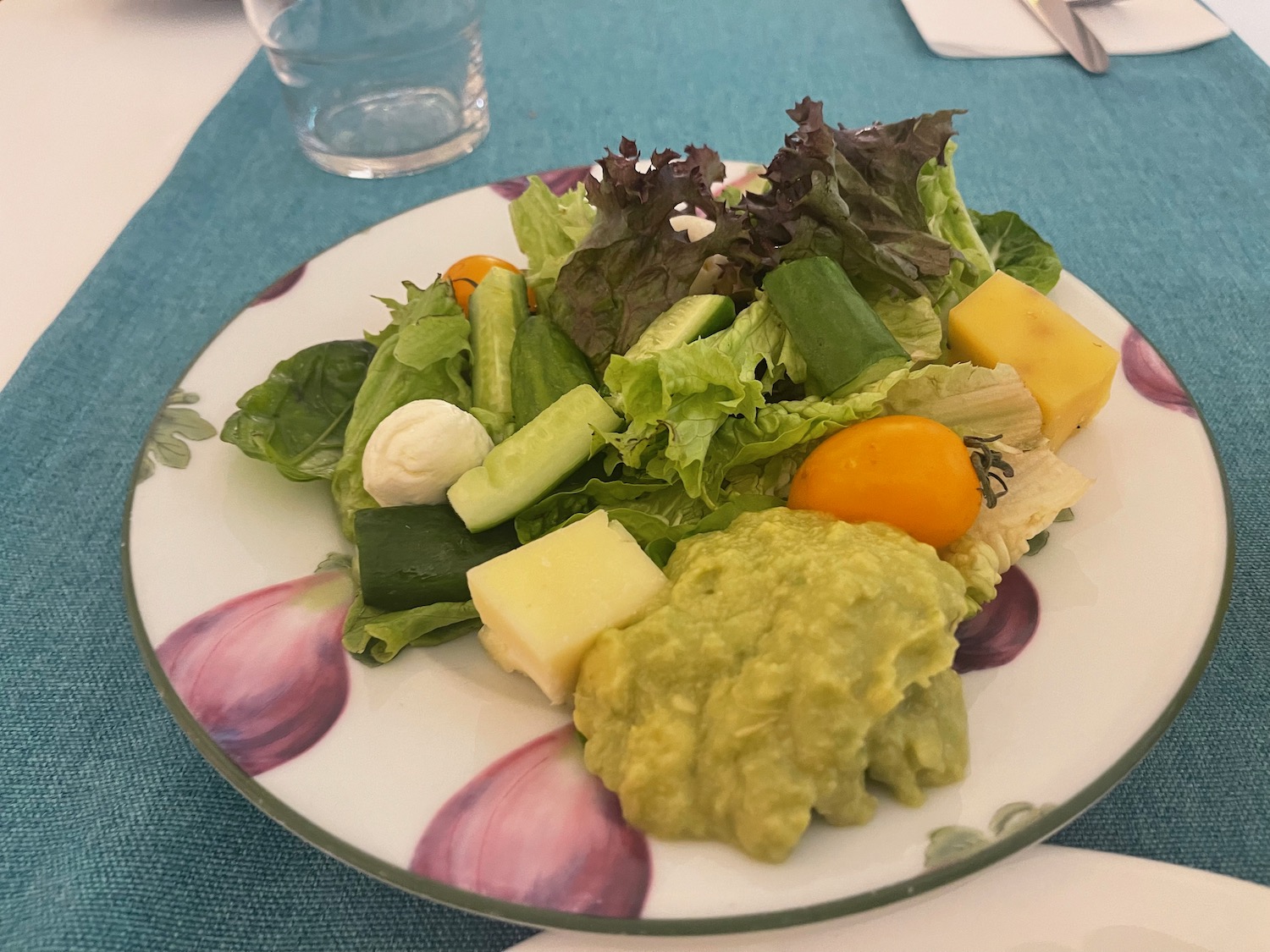 a plate of salad with guacamole and cheese