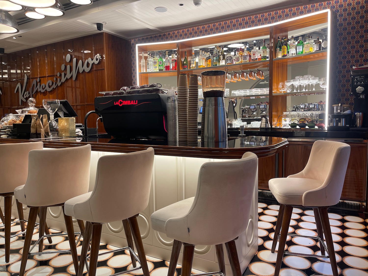 a bar with white chairs and a black counter