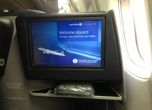 a screen on a shelf in an airplane