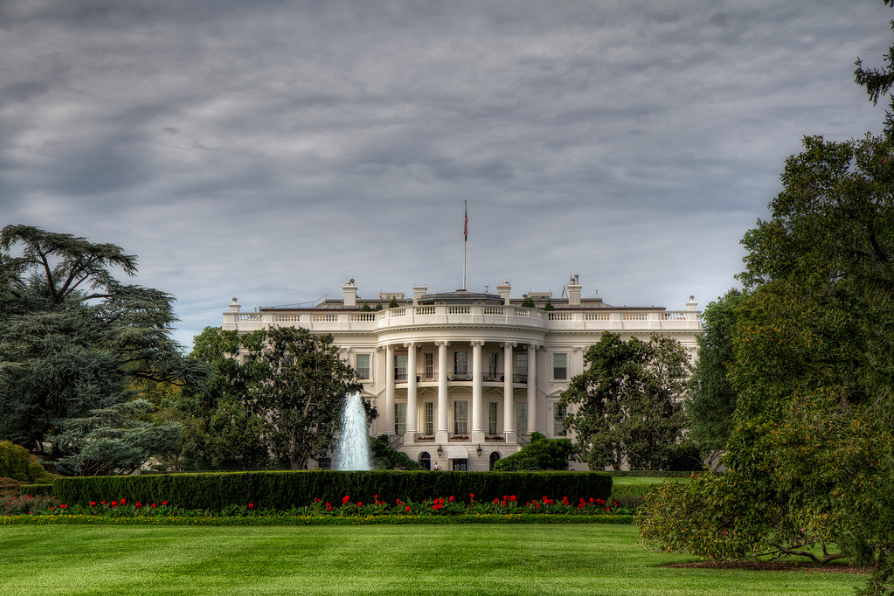 a white house with columns and a fountain in front with White House in the background