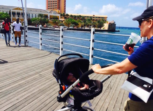 a man pushing a stroller with a baby in it