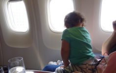 a child sitting on a seat in an airplane