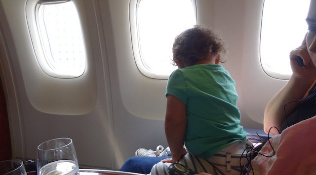 a child sitting on a seat in an airplane