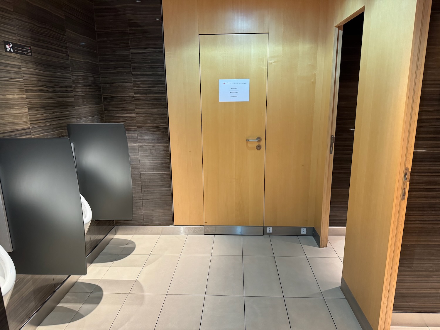 a bathroom with a door and urinals