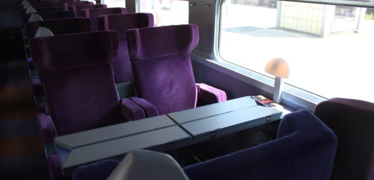 a train with purple seats and a table