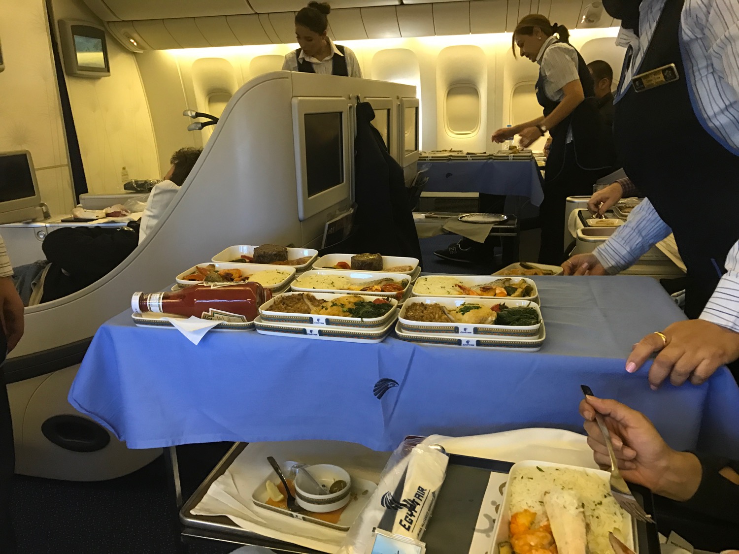 a group of people in an airplane with food on a table