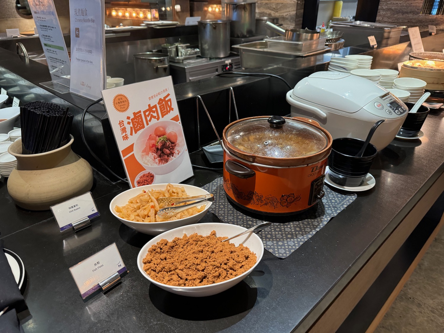 a kitchen counter with bowls of food and a sign