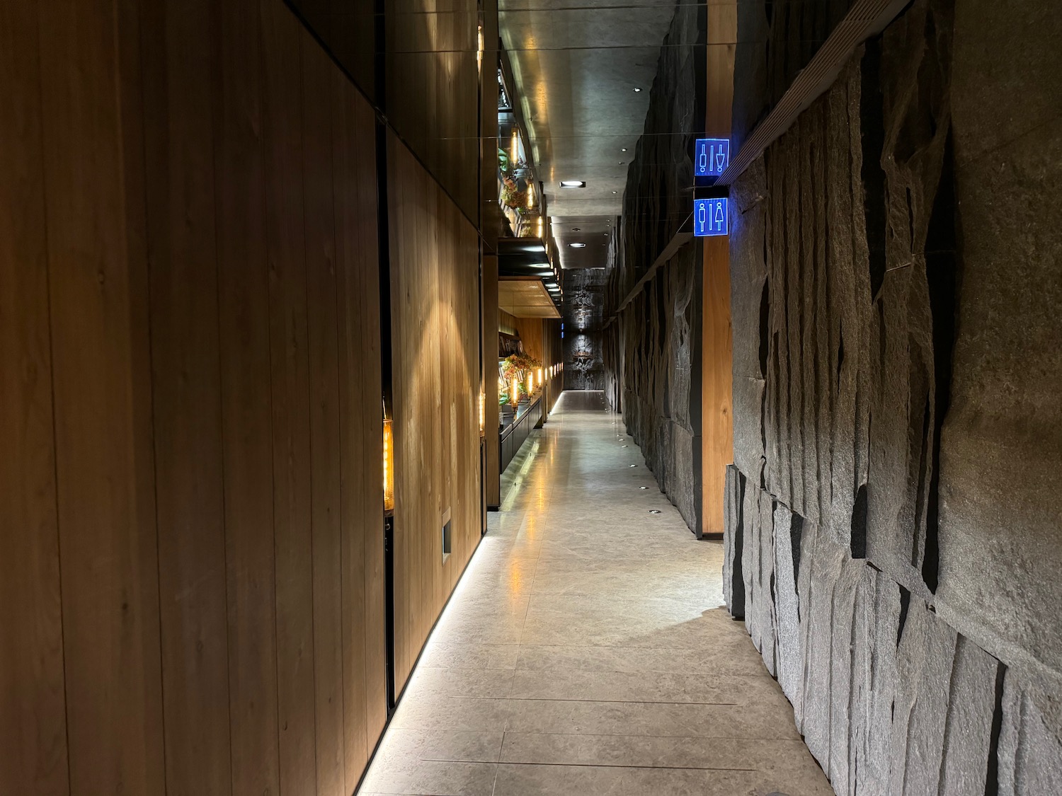 a long hallway with stone walls and lights