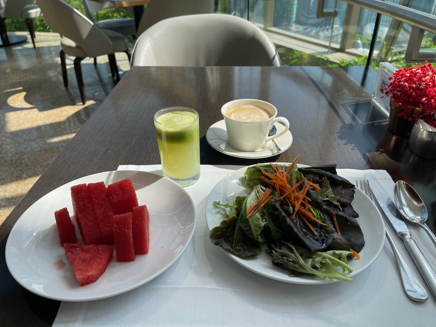 a plate of salad and watermelon on a table