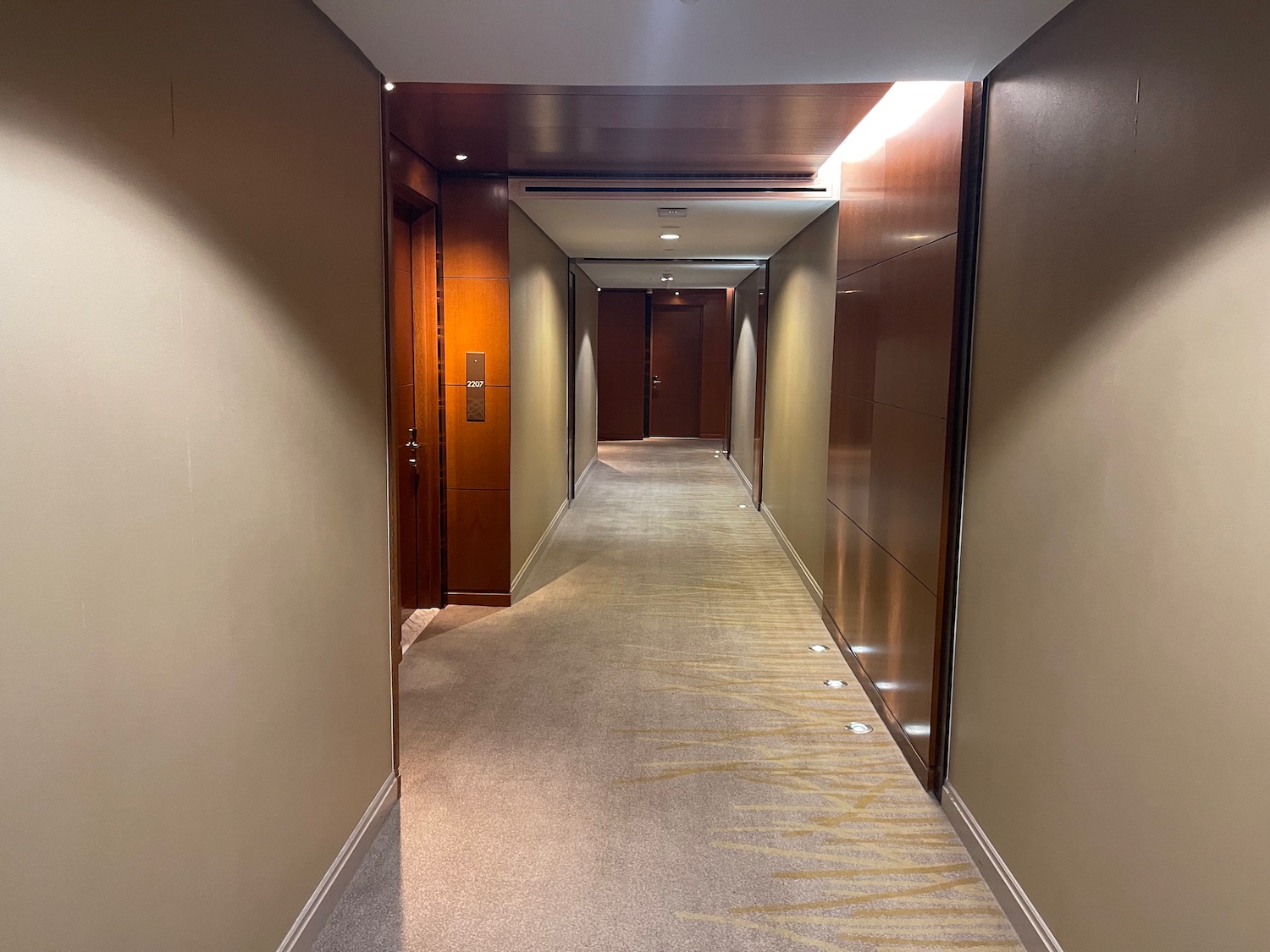 a hallway with wood doors and a carpeted floor