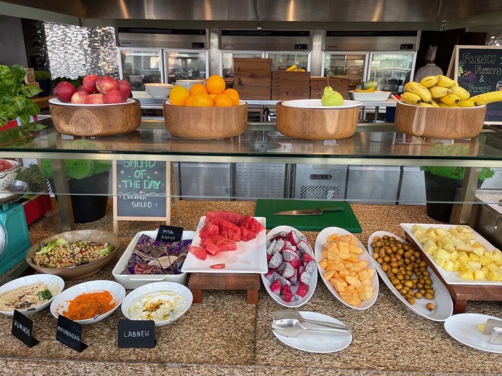 a counter with bowls of fruit and vegetables