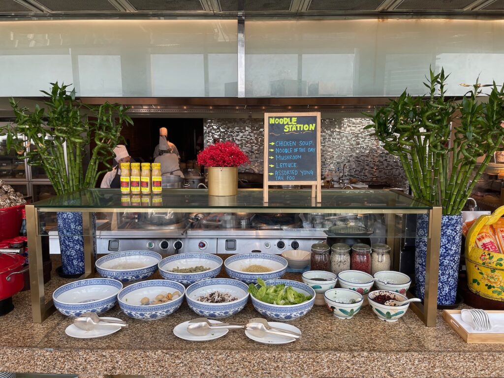 a counter with bowls of food and a sign