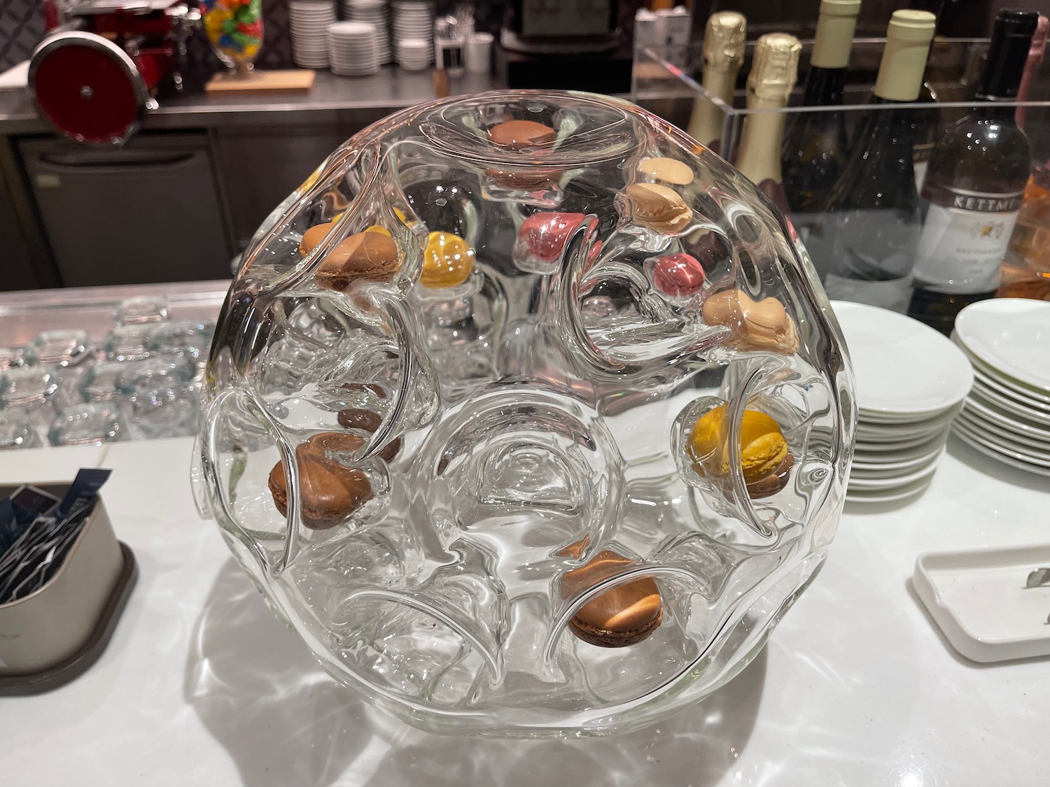 a glass bowl with colorful cookies inside