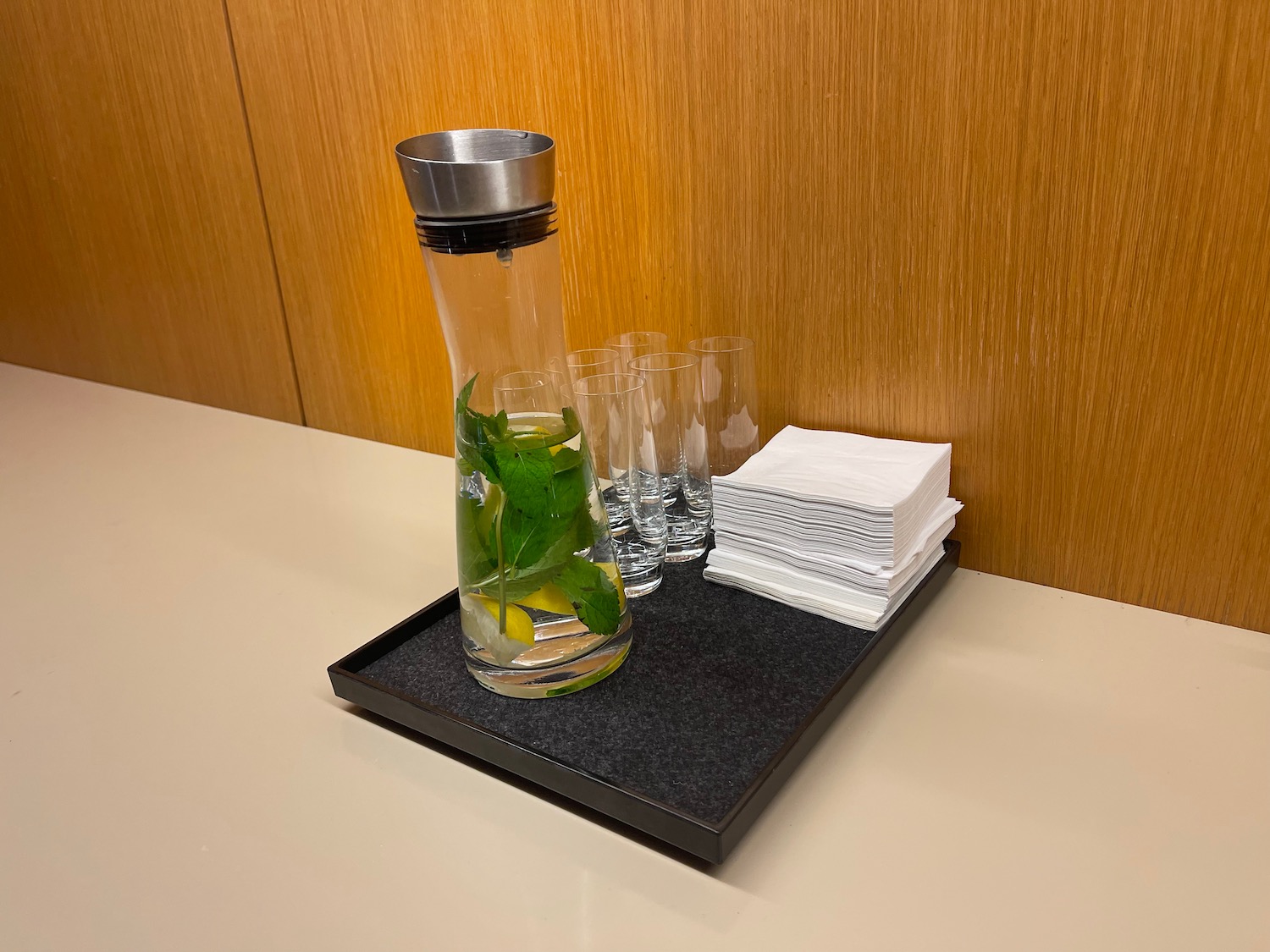 a water bottle with a leaf in it and glasses on a tray