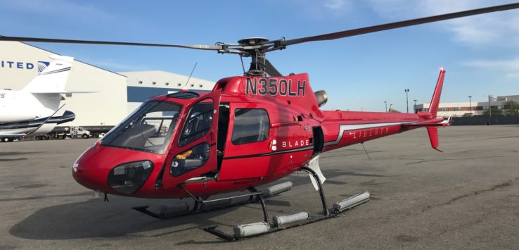 a red helicopter parked on a concrete surface