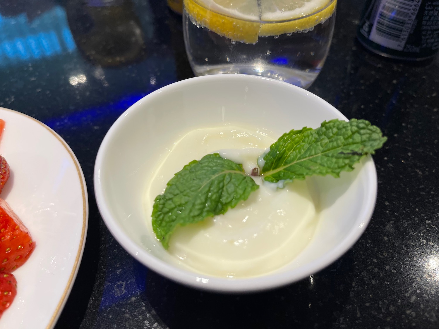 a bowl of white liquid with a green leaf on top