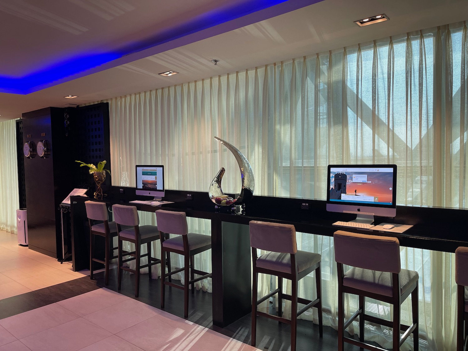 a room with a long table with computers and chairs