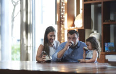 a man and woman sitting at a table with a child