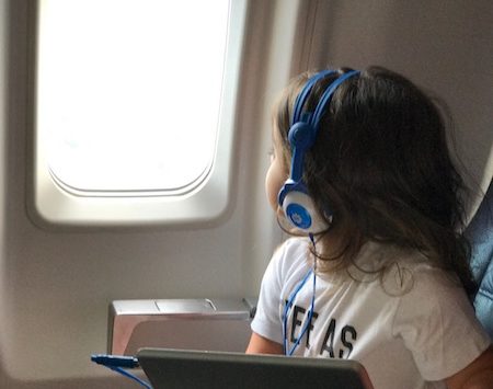 a child wearing headphones and using a tablet