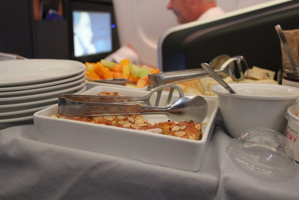 a tray of food with a spoon and plates on a table