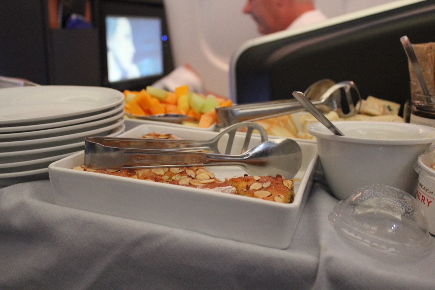 a tray of food with a spoon and plates on a table