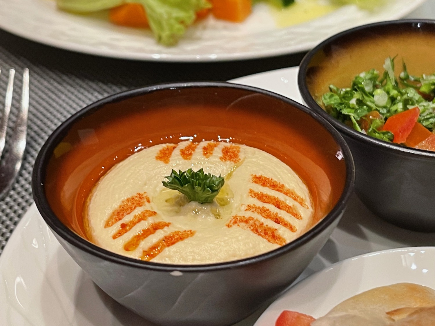 a bowl of hummus with a leafy green garnish