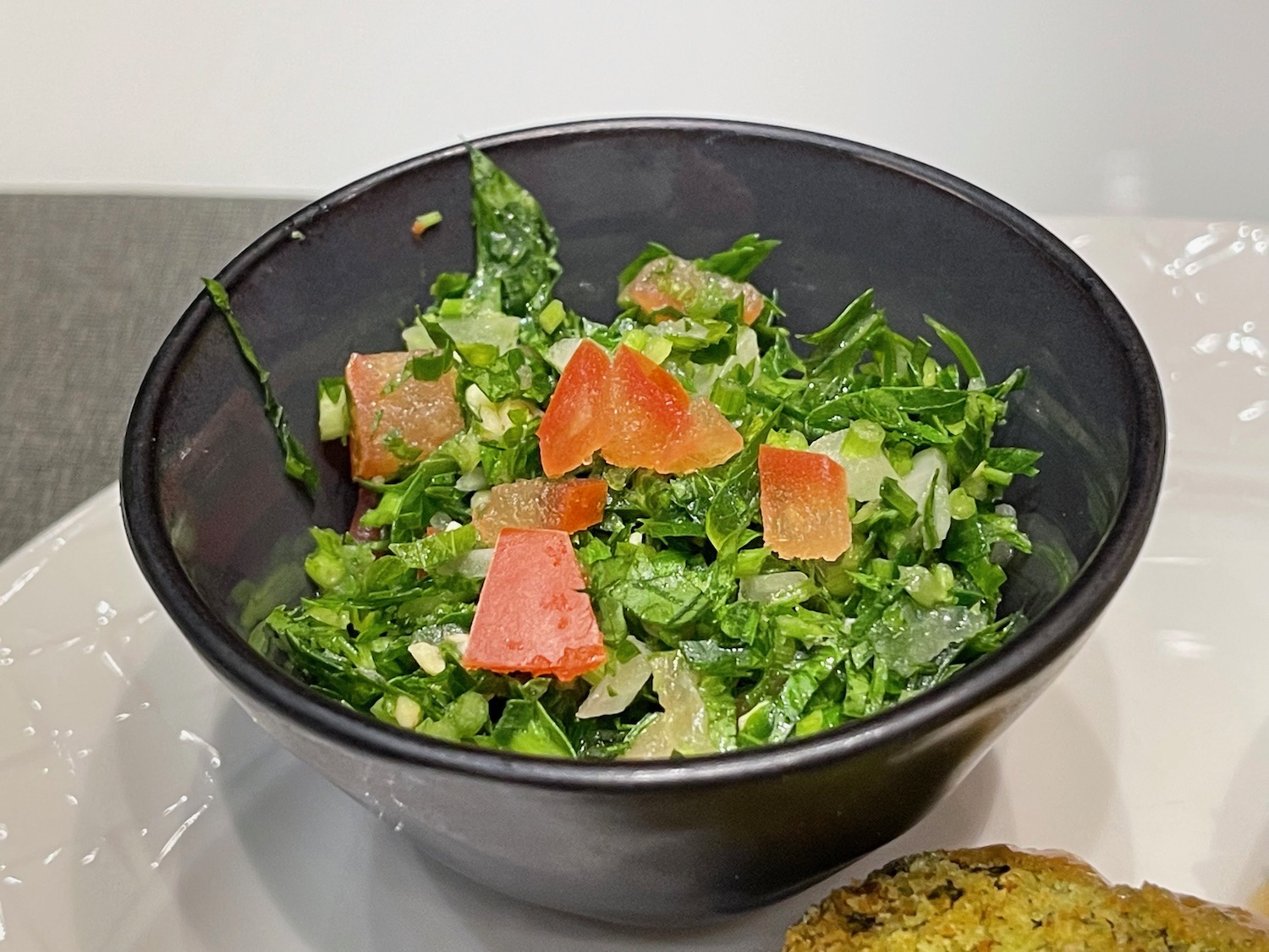 a bowl of salad with tomatoes and greens