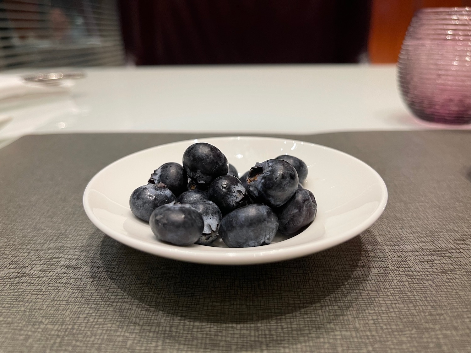 a plate of blueberries on a table