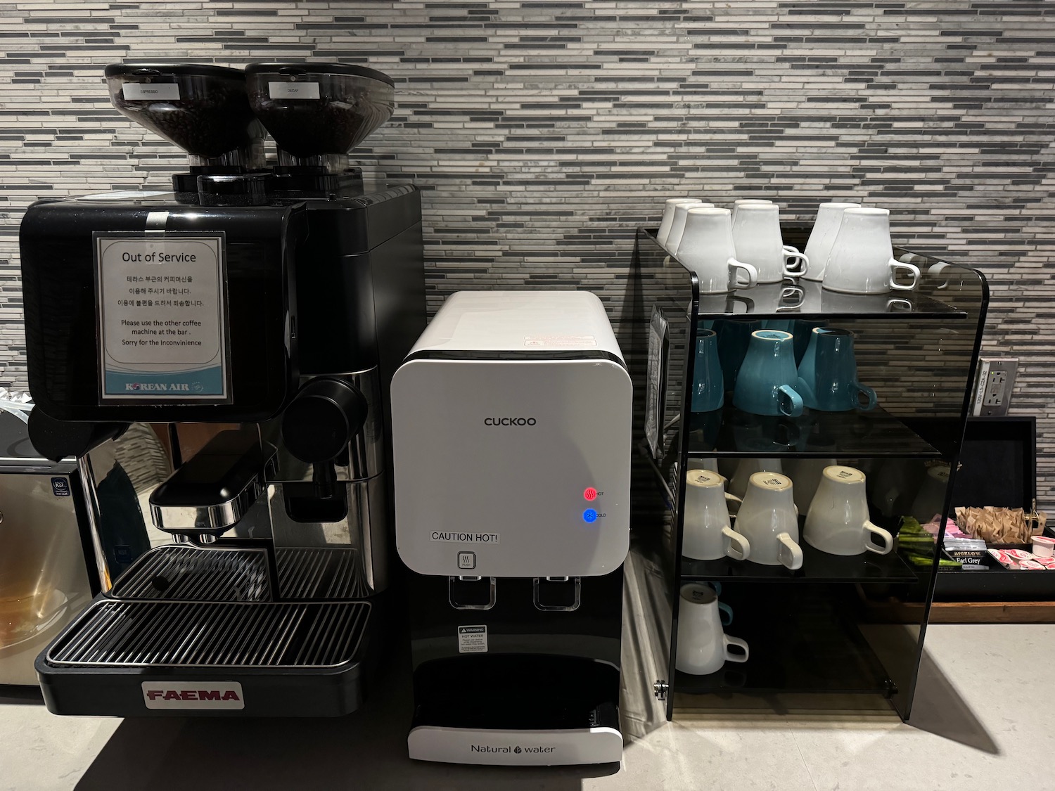a coffee machine and coffee cups on a shelf