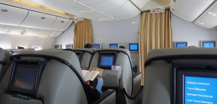 a person sitting in a chair with a book on the back of the seat