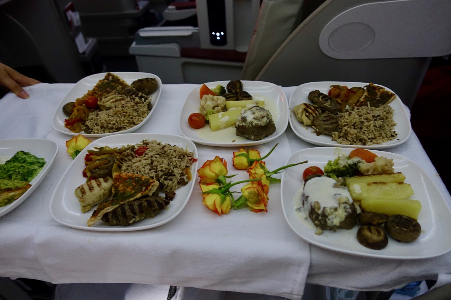 a table with plates of food and flowers