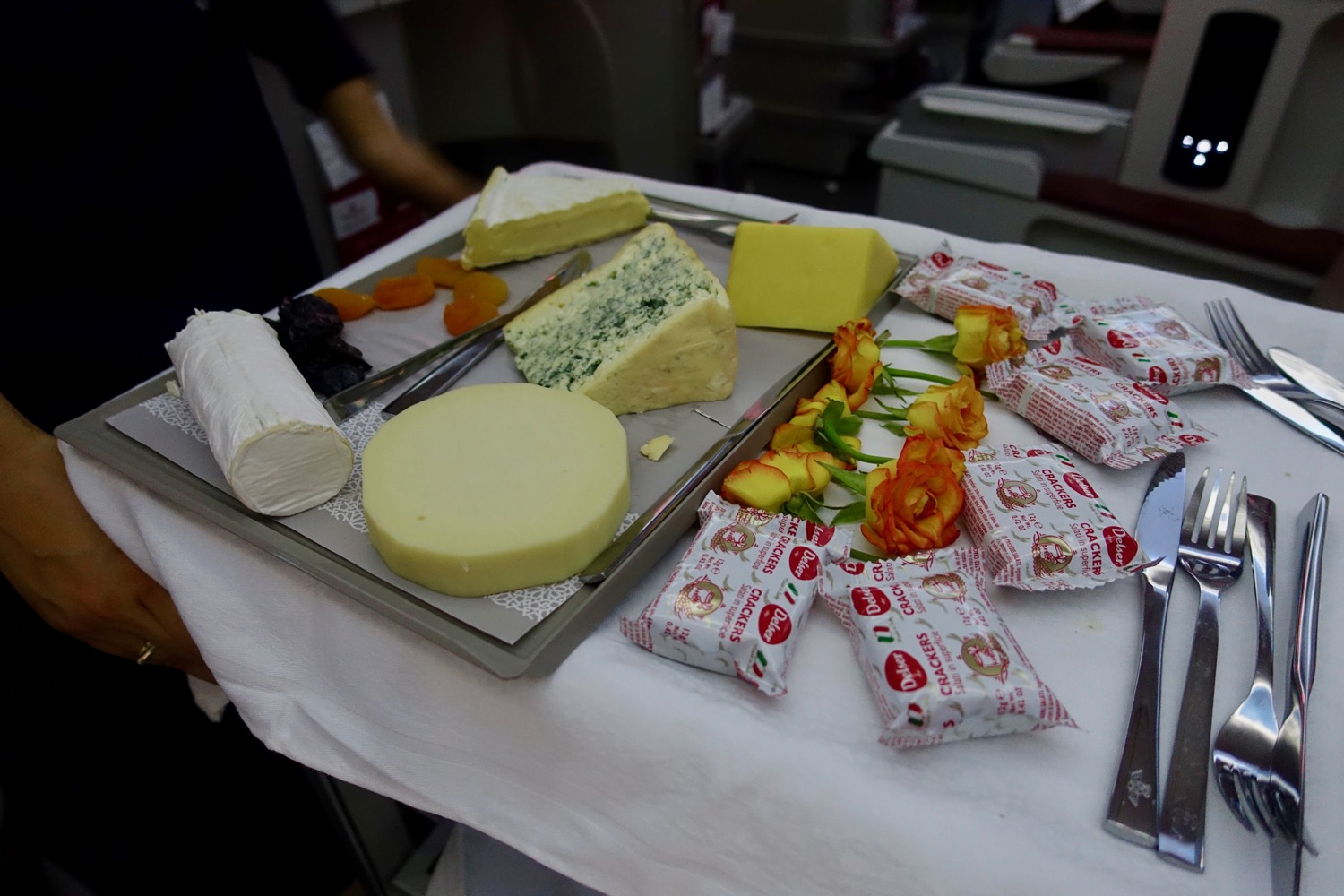 a tray of cheese and flowers on a table