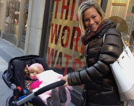 a woman holding a stroller with a baby