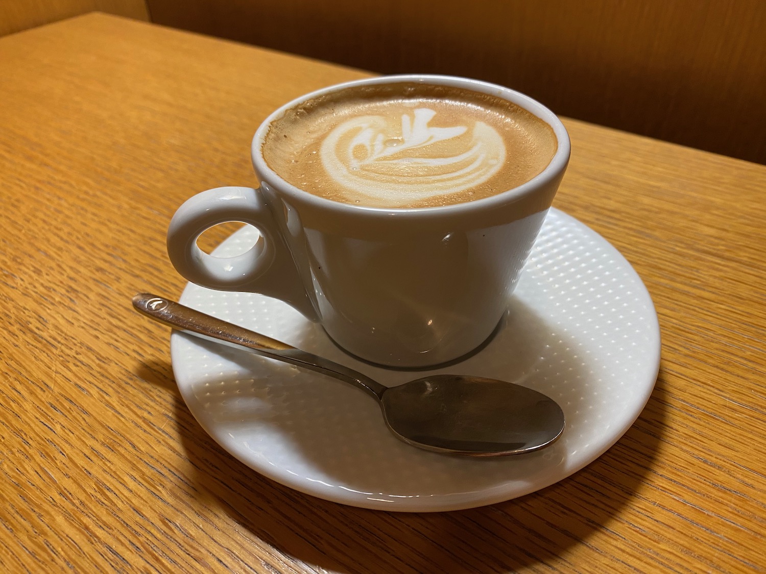 a cup of coffee with a spoon on a saucer