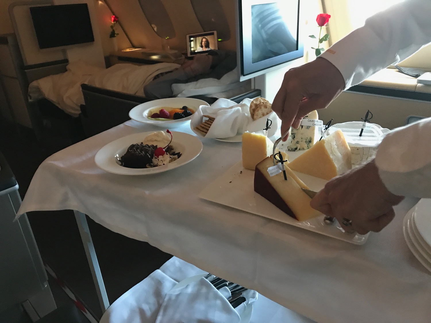 a person cutting a piece of cheese on a table