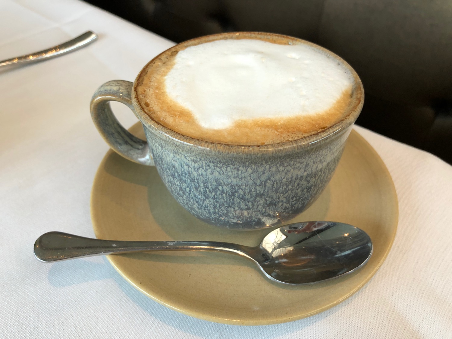 a cup of coffee with a spoon on a saucer