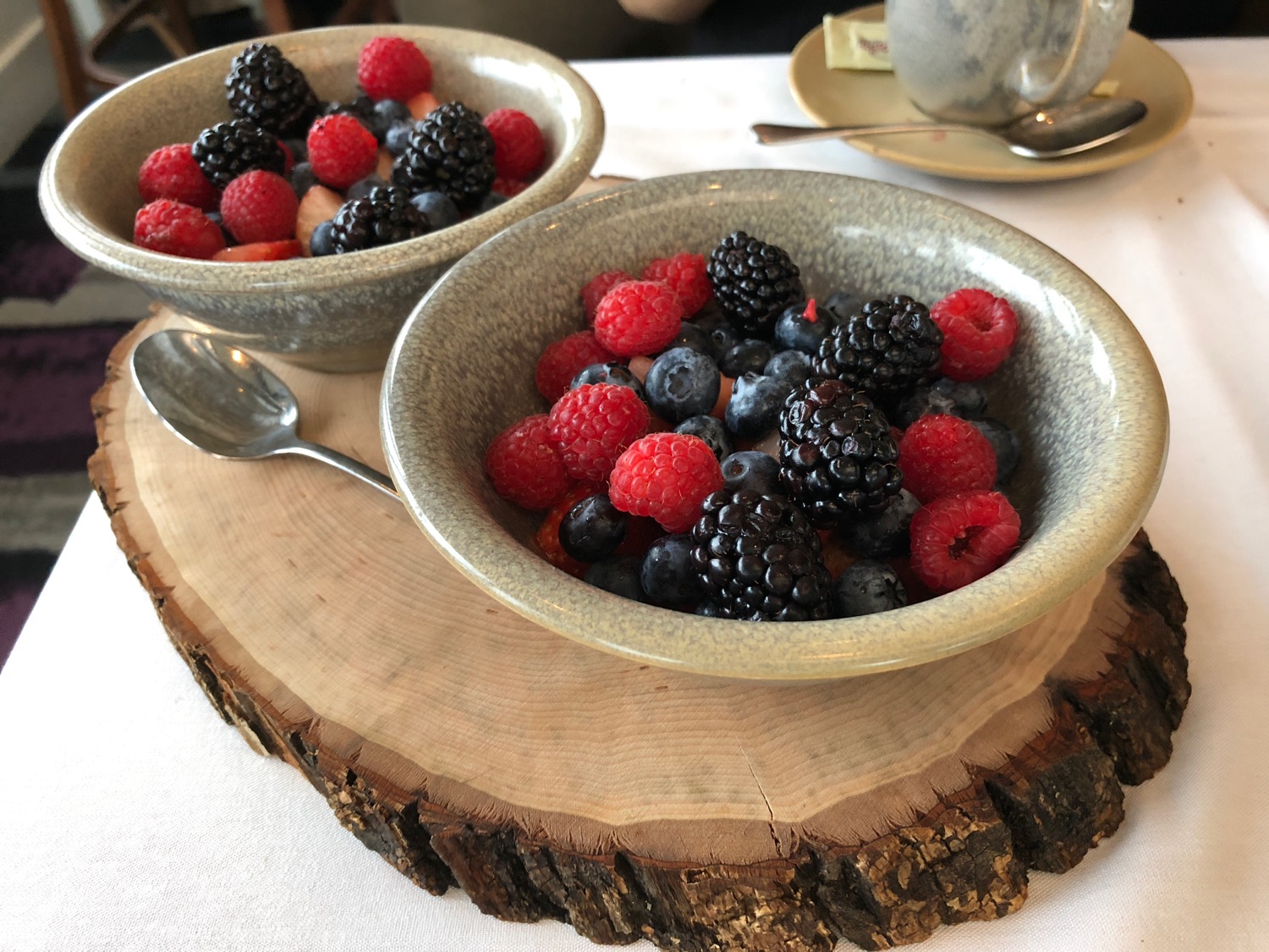 a bowl of berries on a wood slab