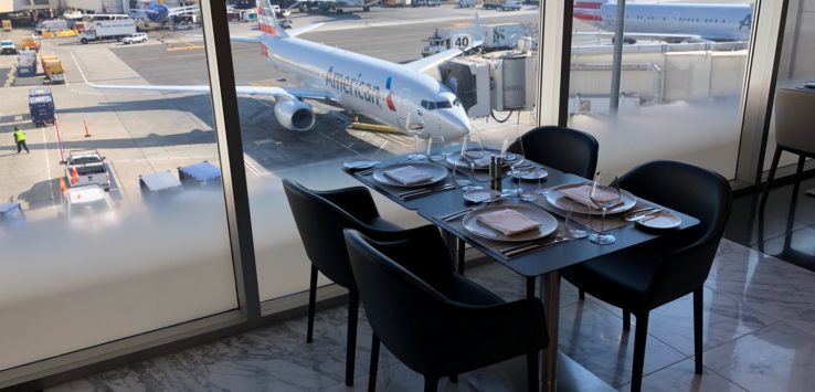 a table with plates and chairs in front of an airplane