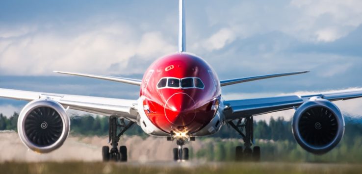 a red and white airplane on a runway