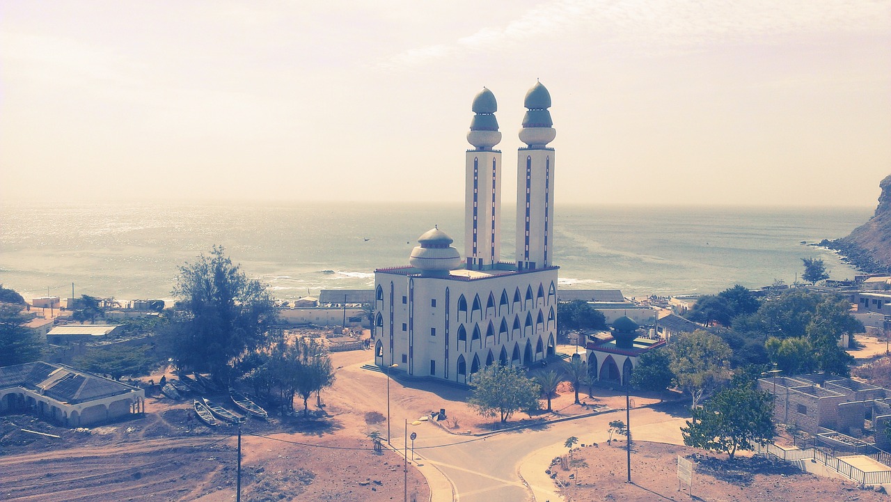 a building with towers and a beach in the background