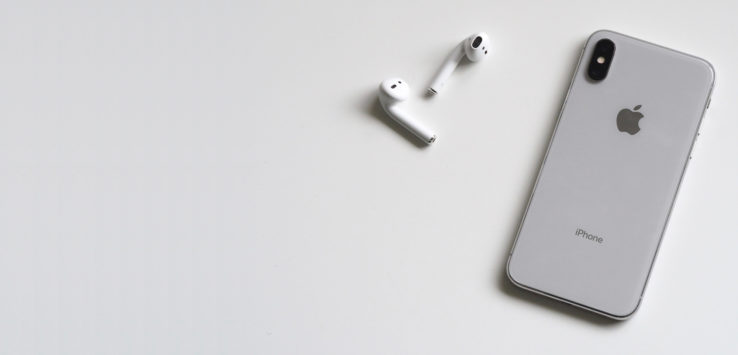 a white earbuds next to a laptop