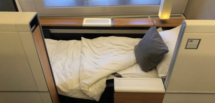 a bed with a pillow and a lamp in a plane
