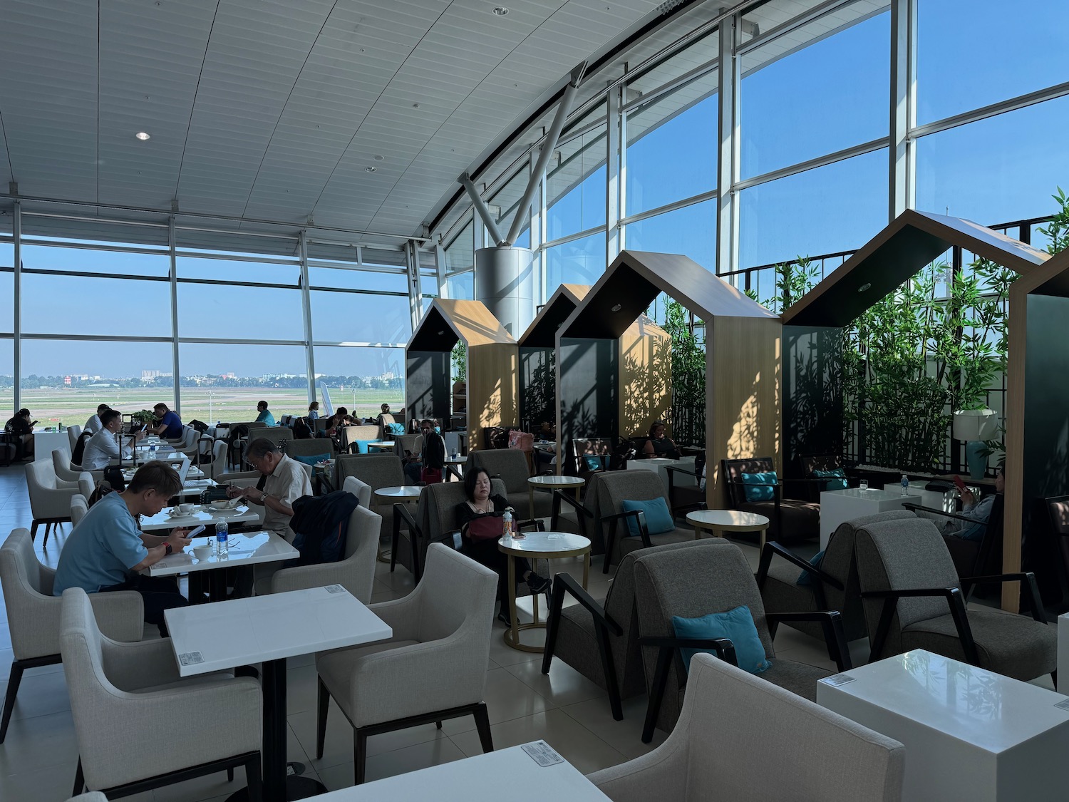 a group of people sitting at tables in a room with large windows