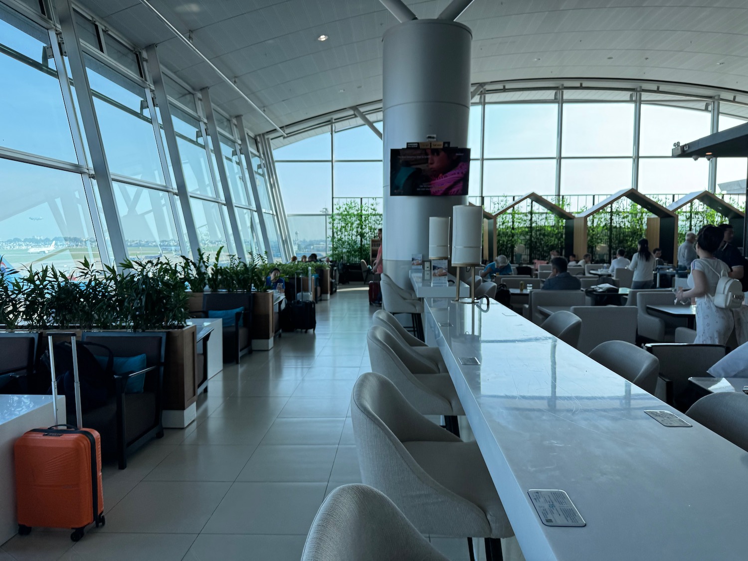 a room with large windows and tables and chairs