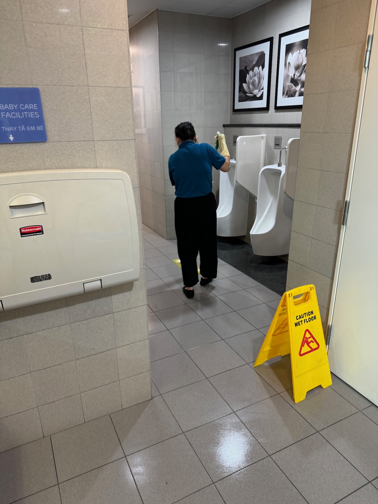 a person cleaning urinals in a bathroom