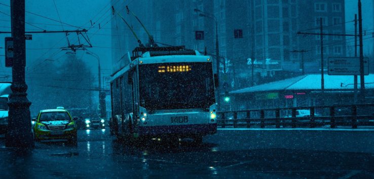a bus driving down a street in the rain