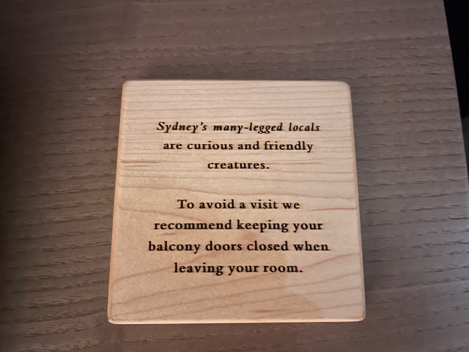 a wooden square sign with black text on it